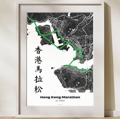 Framed map poster of Hong Kong with marathon route highlighted, on a light wooden floor.